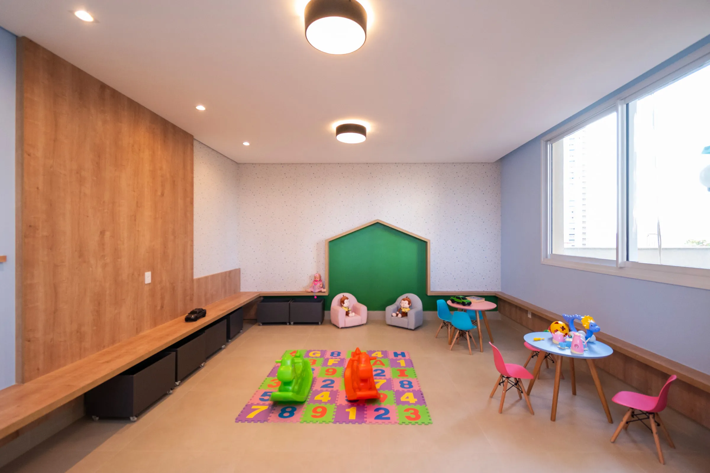 Brinquedoteca do Sky Garden, com tatame colorido e mesas infantis
