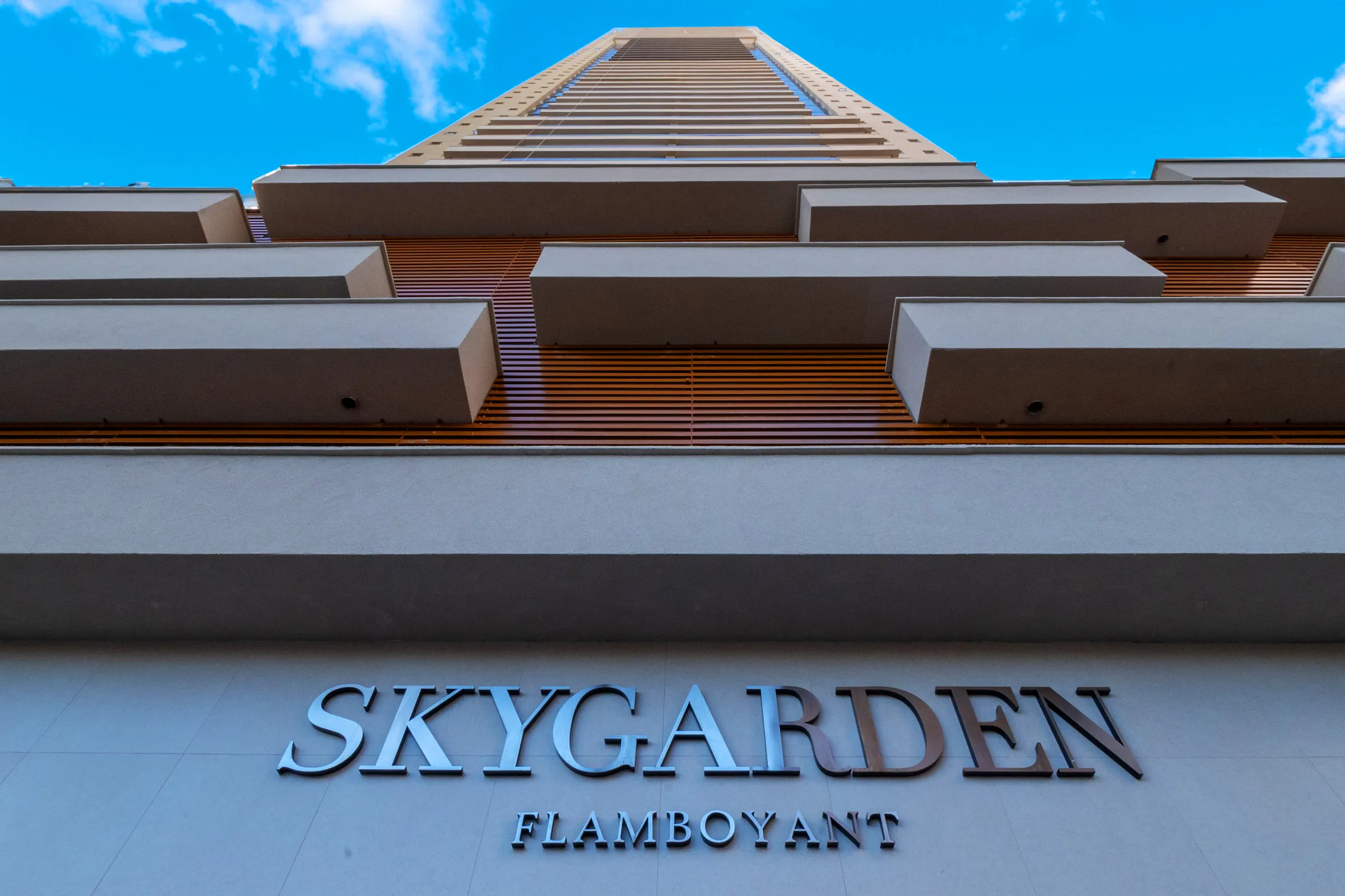 Letreiro SKYGARDEN FLAMBOYANT na fachada da torre, visto de baixo