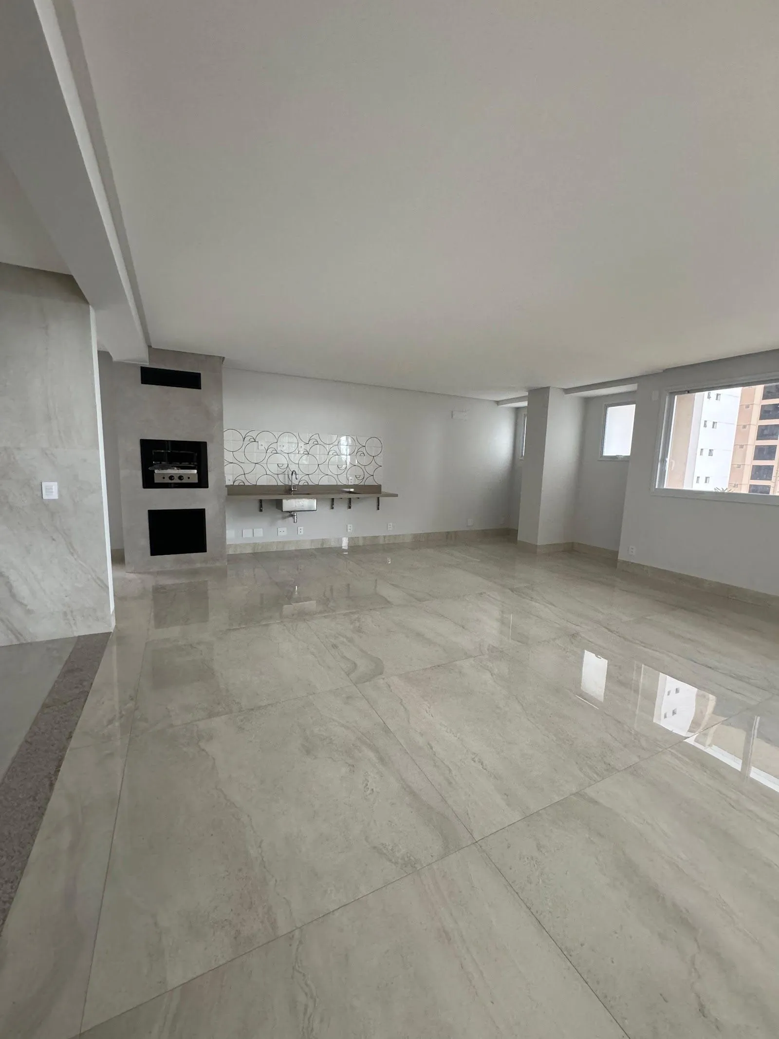 Parede da churrasqueira no living da unidade 1001, com bancada e revestimento decorado